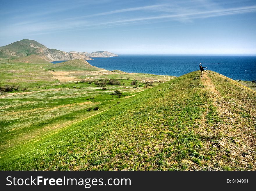 Spring landscape with hills, sea and man