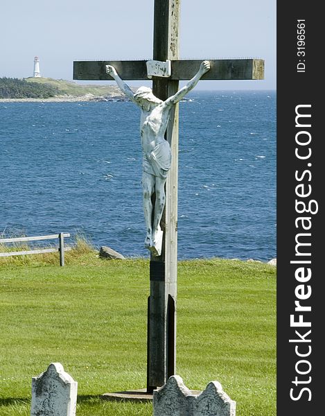 Statue of Christ on cross at waterfront graveyard