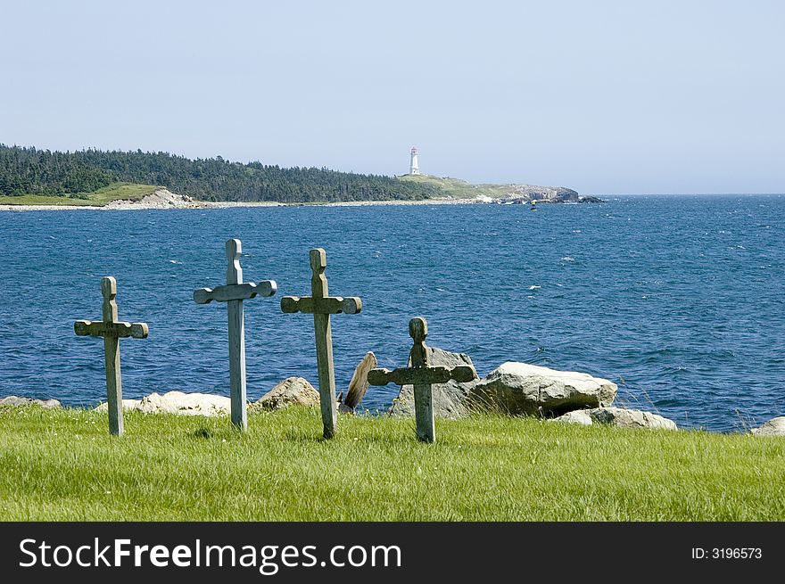 Four stone grave markers in a cemetery at water's edge. Four stone grave markers in a cemetery at water's edge