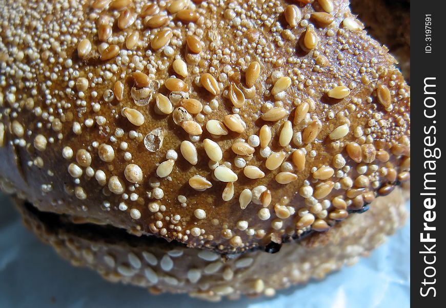 A closeup of a sesame bagel filled with cream cheese