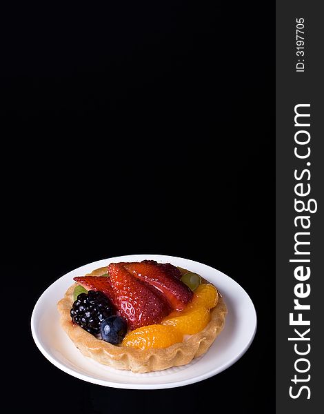 Fruite cake on a saucer isolated on black. Fruite cake on a saucer isolated on black