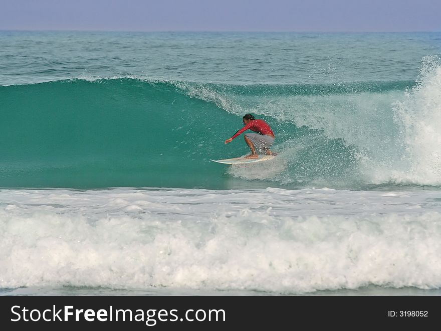 A surfer gets barreled in a perfect glassy wave in Thailand. A surfer gets barreled in a perfect glassy wave in Thailand