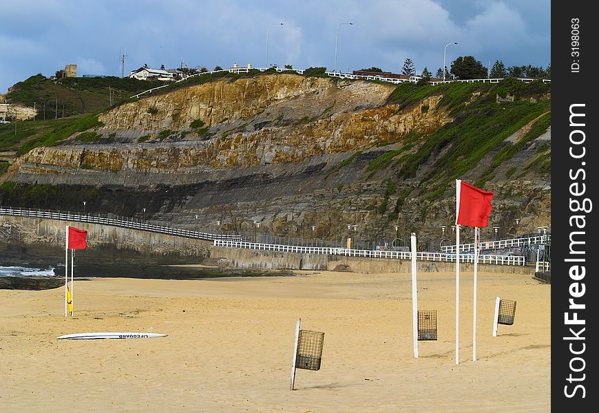 A beach scene with red flags indicating it is closed to swimming. A beach scene with red flags indicating it is closed to swimming