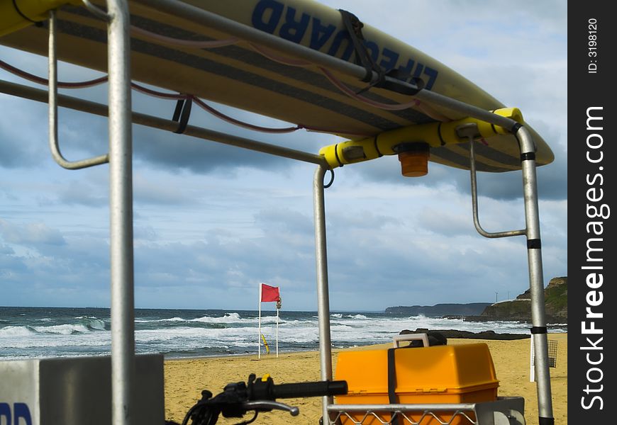 A lifeguard vehicle with resuce board overlooking a wild beach. A lifeguard vehicle with resuce board overlooking a wild beach.