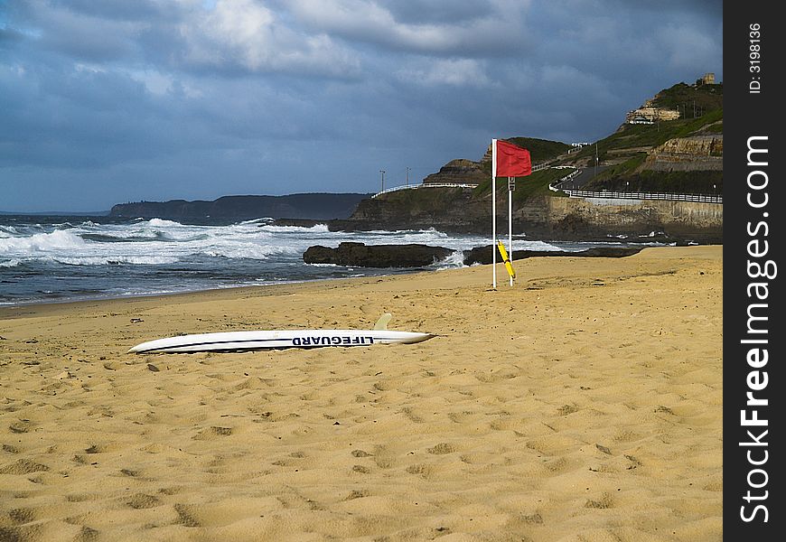 An empty beach with the lifeguard rescue board on the sand