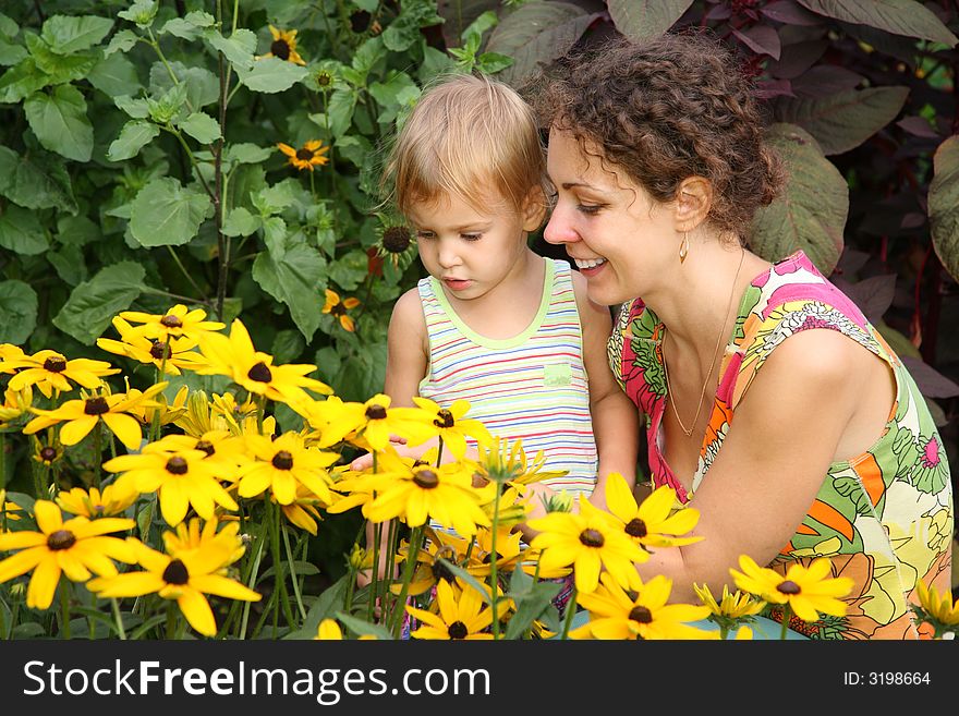 Mother and daughter look on flowers