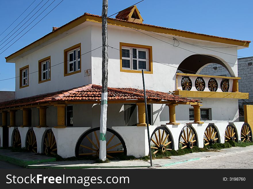 A white building with wheels used as a decoration. A white building with wheels used as a decoration