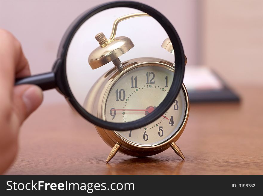 An image of alarm clock through a magnifier. An image of alarm clock through a magnifier