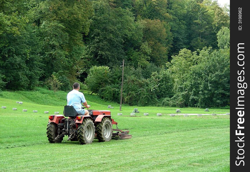 Men with tractor on the green grass field