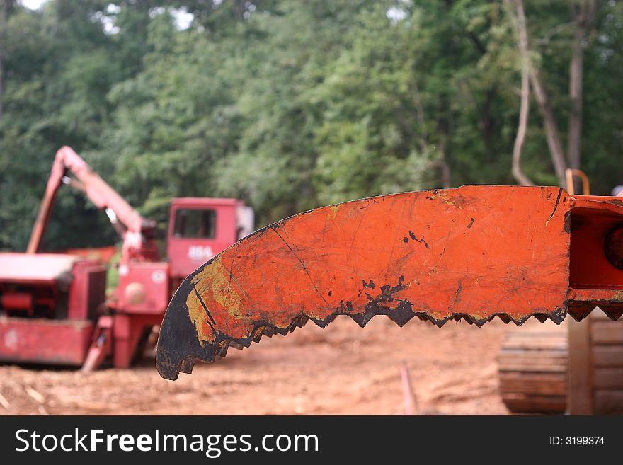 An orange blade on construciton equipment at a job site