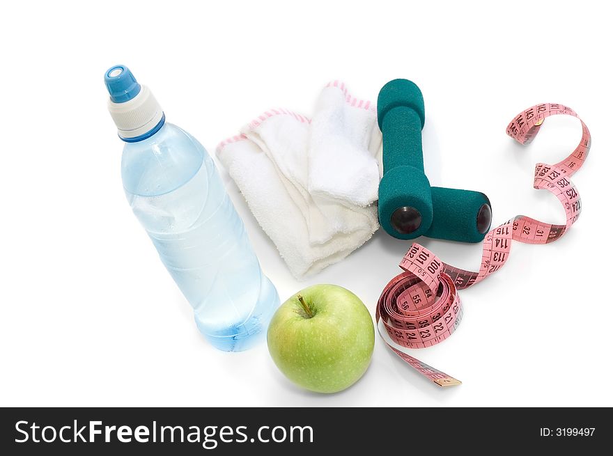 Dumbells, apple and measuring tape on a white background