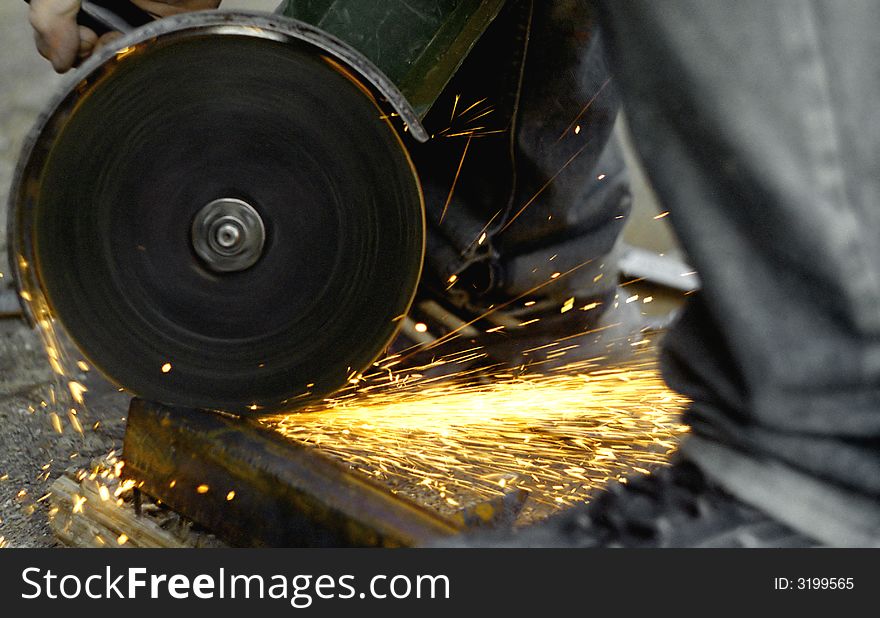 A spinning angle grinder saw sparkles around. A spinning angle grinder saw sparkles around.