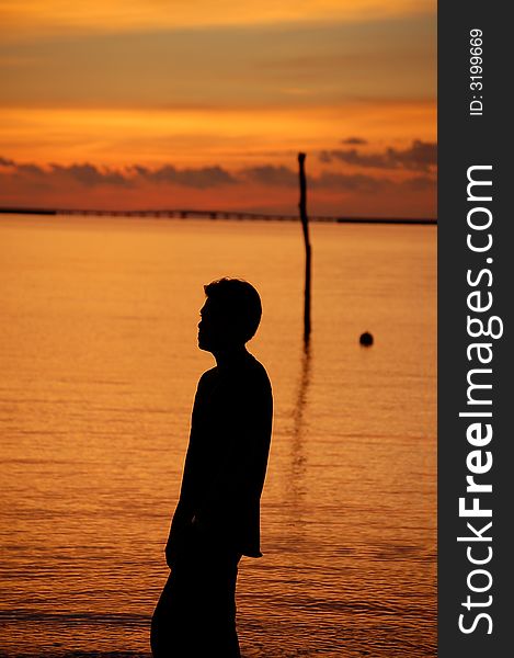 A man standing by sea in the sunset in Langkawi, Malaysia. A man standing by sea in the sunset in Langkawi, Malaysia.