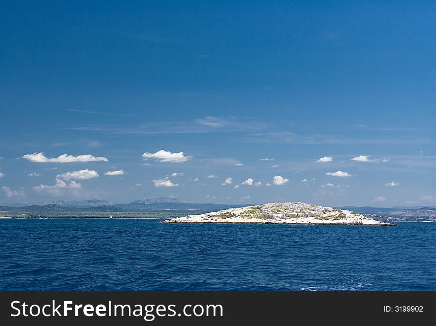 Island in blue sea water. Island in blue sea water.