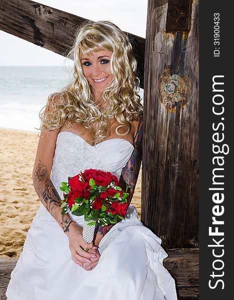 Beautiful young bride under the pier at the beach just married. Beautiful young bride under the pier at the beach just married.