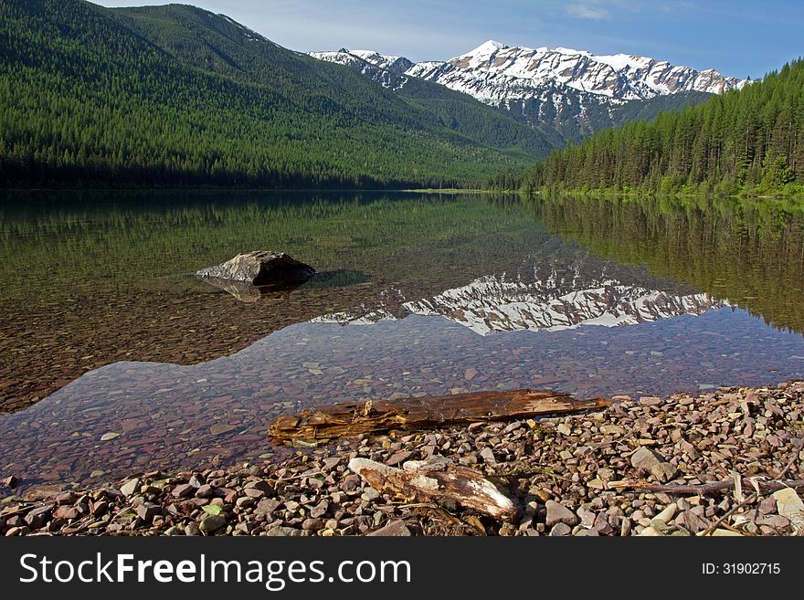 This image of the snowy mountain in the background and reflected in the water was taken at Stanton Lake in the Great Bear Wilderness of NW Montana. This image of the snowy mountain in the background and reflected in the water was taken at Stanton Lake in the Great Bear Wilderness of NW Montana.