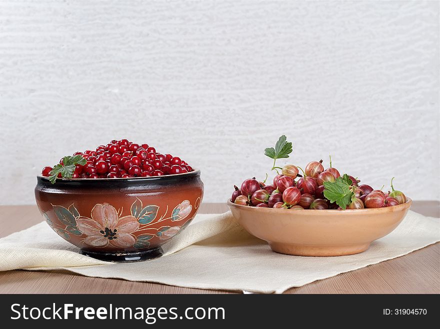 Two ceramic bowl with fresh berries currants and gooseberries