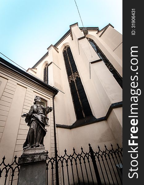 Old ancient statue in front of church i Lviv, Ukraine