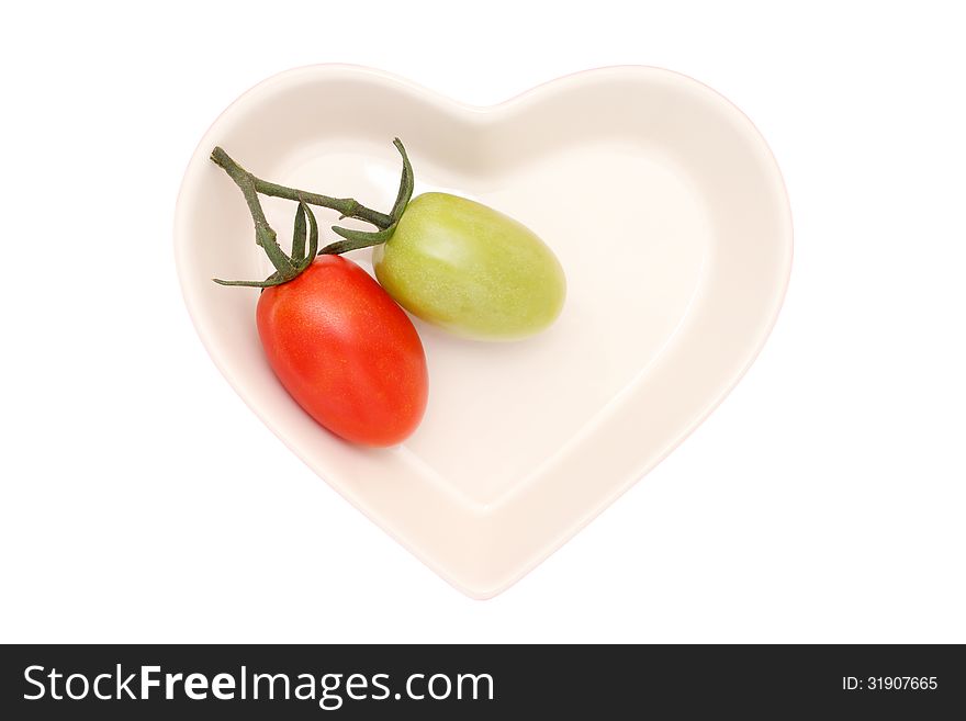Branch of the two cherry tomatoes on heart-shaped plate