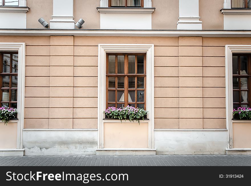 Brown wooden windows decorated with pink flowers. Brown wooden windows decorated with pink flowers