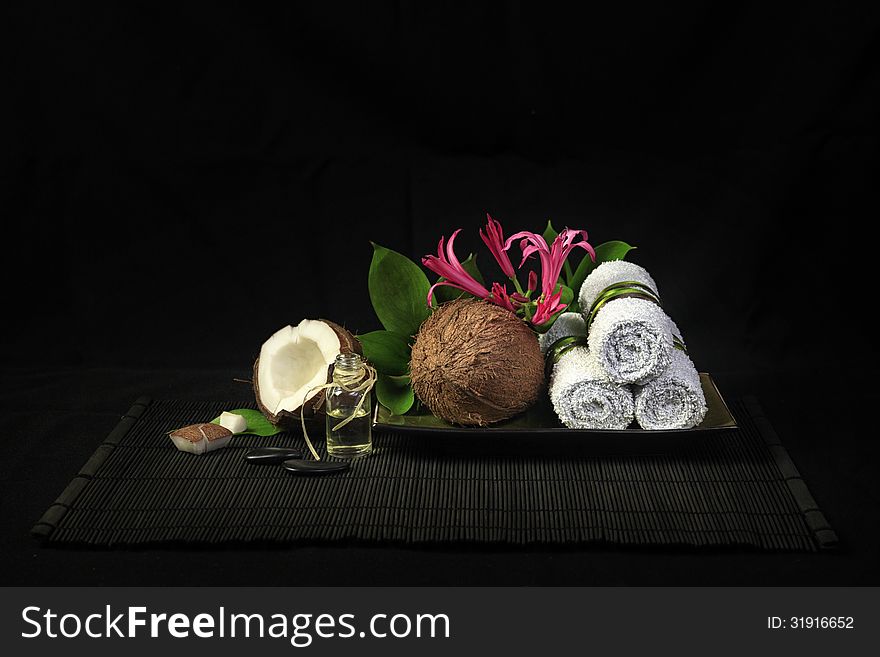 Spa composition with towels, flowers and coconut oil