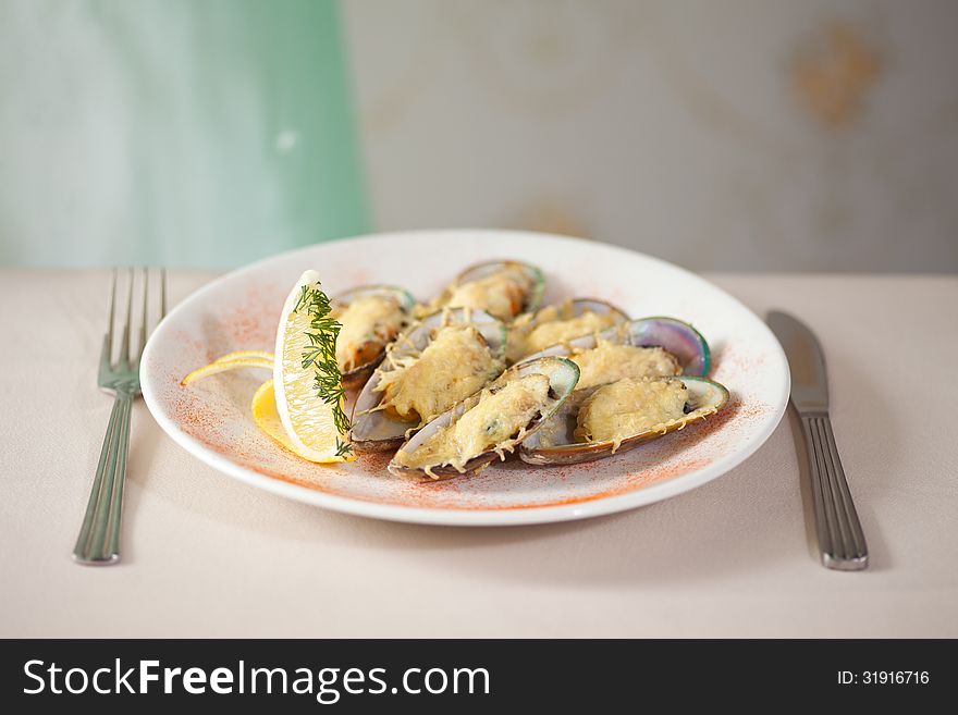 Jpened mussels on plate with fork and knife. Jpened mussels on plate with fork and knife