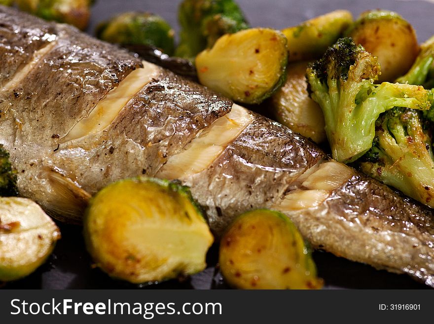 Fried fish with Brussels sprouts, broccoli and lemon