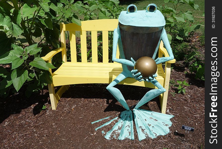 Frog Bronze Statue On Yellow Bench.