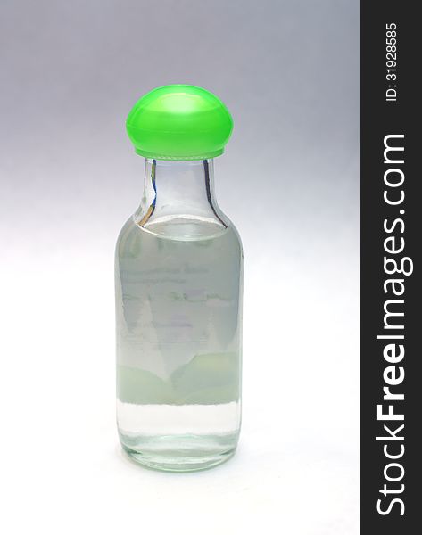 Glass bottle of water with green lid