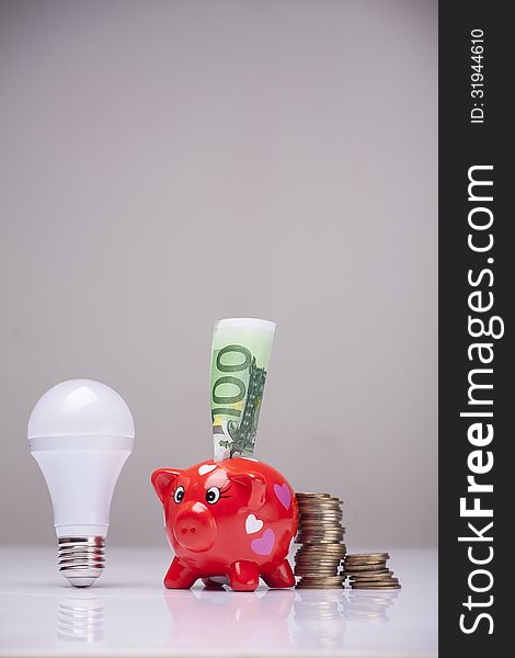 Piggy bank and savings going from the use of LED light bulbs. Piggy bank and savings going from the use of LED light bulbs