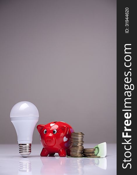 Piggy bank and savings going from the use of LED light bulbs. Piggy bank and savings going from the use of LED light bulbs