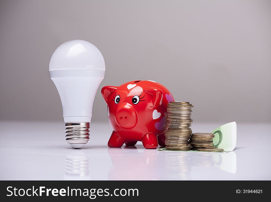 Piggy bank and savings going from the use of LED light bulbs. Piggy bank and savings going from the use of LED light bulbs