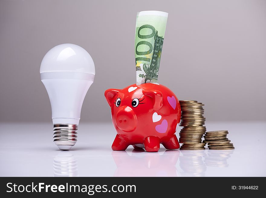 Piggy bank and savings going from the use of LED light bulbs. Piggy bank and savings going from the use of LED light bulbs