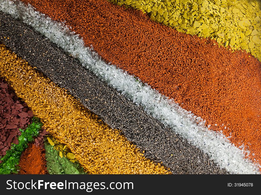 Close up on an abstract composition made by multicolored sand and pebbles. Close up on an abstract composition made by multicolored sand and pebbles