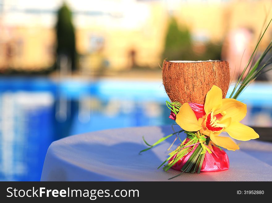 A glass of coconut decorated with orchid