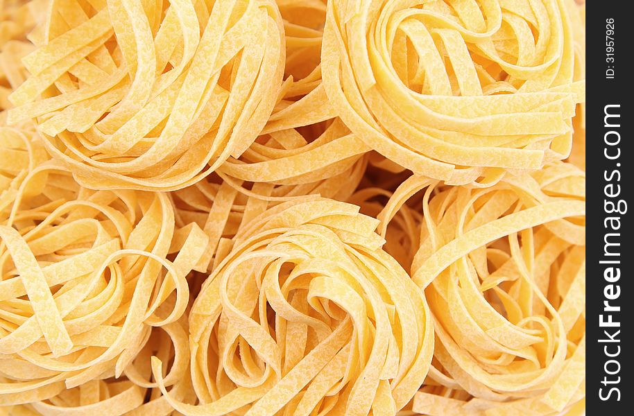 Yellow pasta fettuccine on a whole background. Yellow pasta fettuccine on a whole background