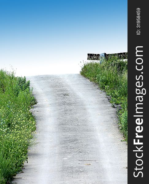 Road on the heaven. Dirt road. Green grass. Blue sky.