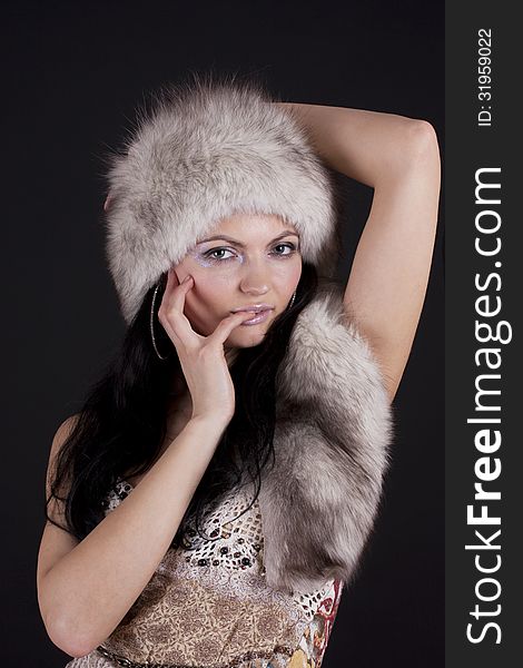 Beautiful young woman wearing fur-cap, isolated on black. Beautiful young woman wearing fur-cap, isolated on black.