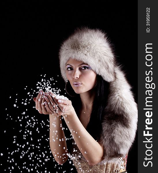 Winter woman blowing christmas snow from hands, isolated on black. Winter woman blowing christmas snow from hands, isolated on black.