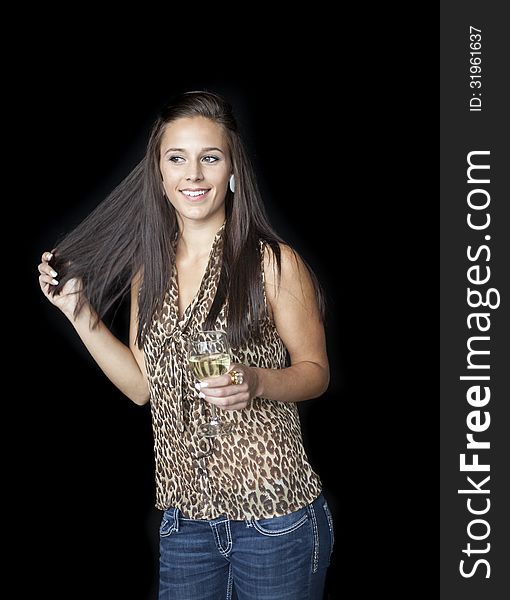 Beautiful young woman with brown hair and eyes in a leopard skin top with a glass of white wine.