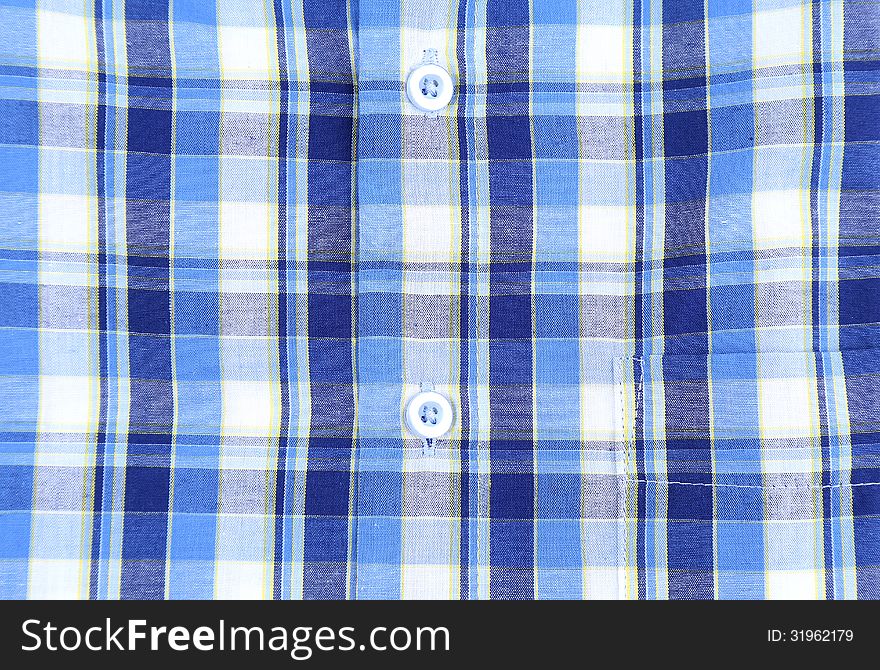 Plaid man shirt, button close-up on a whole background. Plaid man shirt, button close-up on a whole background