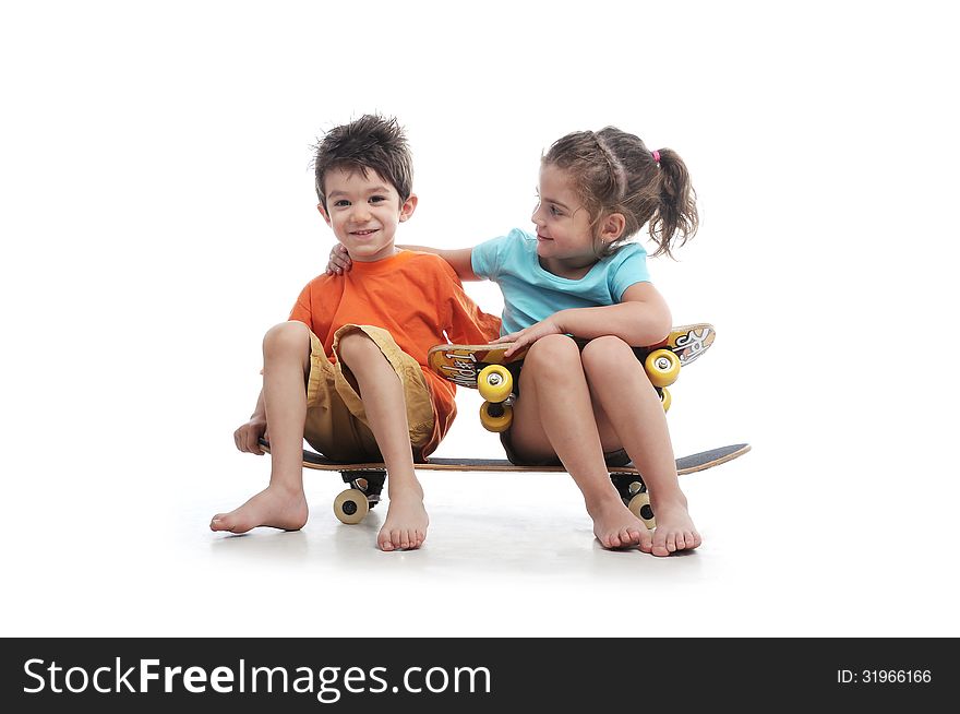 Photography of preschool boy and girl are sitting on a big skate board in a studio on white background. Photography of preschool boy and girl are sitting on a big skate board in a studio on white background