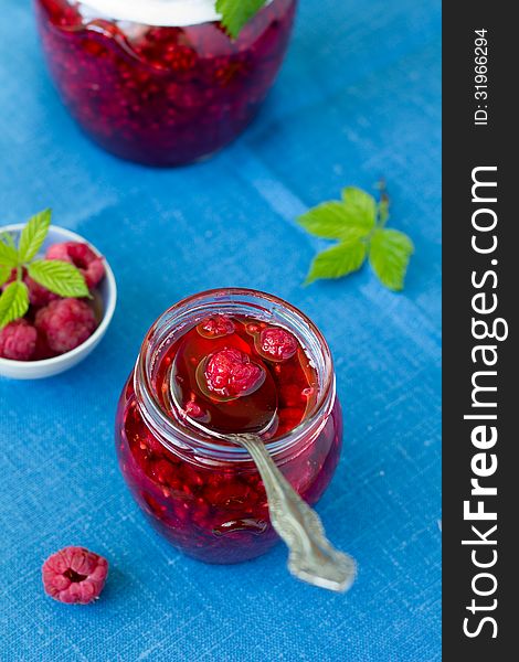 Raspberry jam in a jar and fresh berries