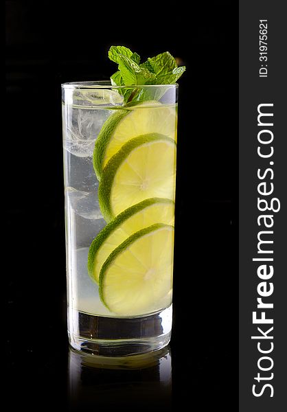 Lemonade with lime and ice on a black background