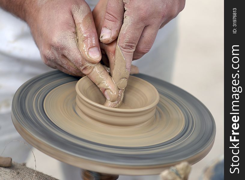 Hands working on pottery wheel