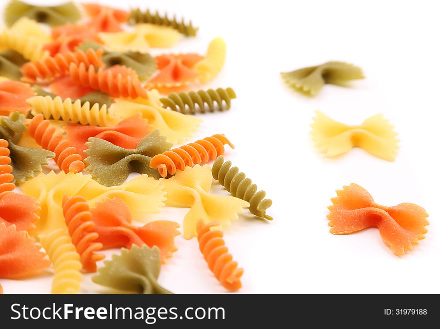 A different pasta in three colors close-up on the white background. A different pasta in three colors close-up on the white background.