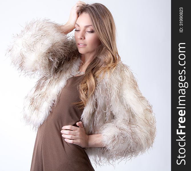 An image of a gorgeous woman in a beige fur coat. An image of a gorgeous woman in a beige fur coat