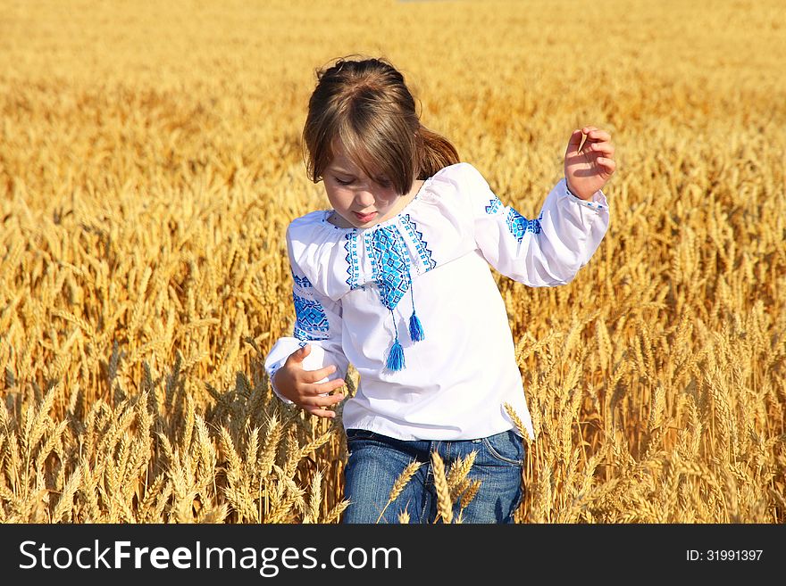 Small rural girl on wheat field