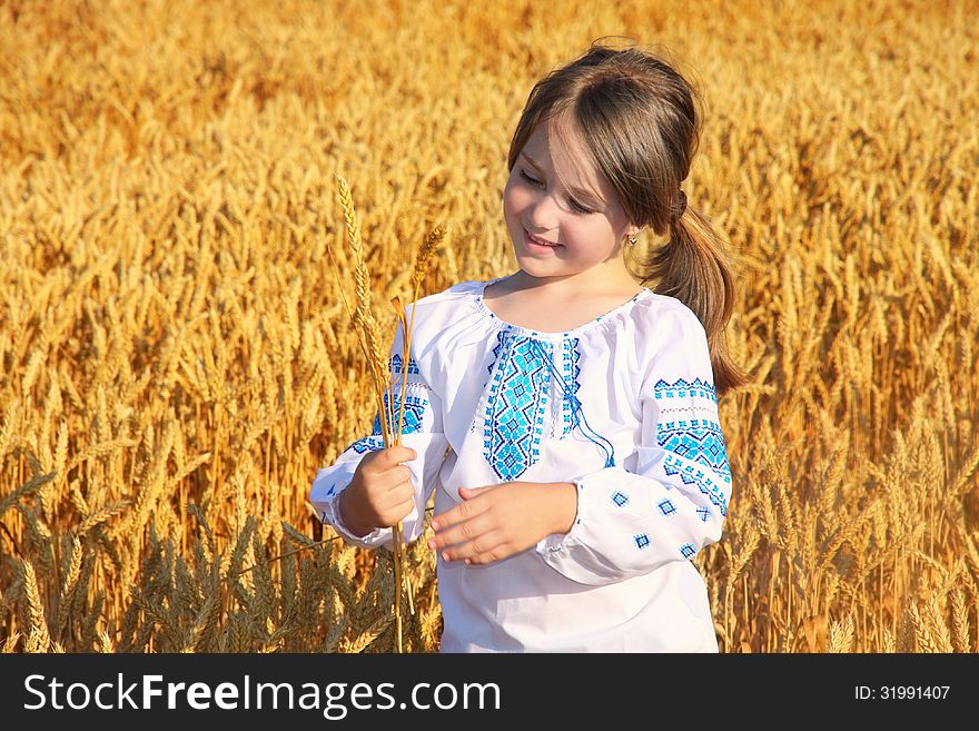 Small rural girl on wheat field