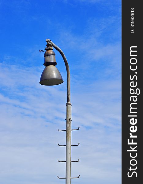 One lamp on railway track and blue sky on the background. One lamp on railway track and blue sky on the background